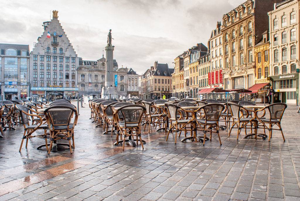 Lille City Centre with chairs and tables outside, surrounded by buildings.