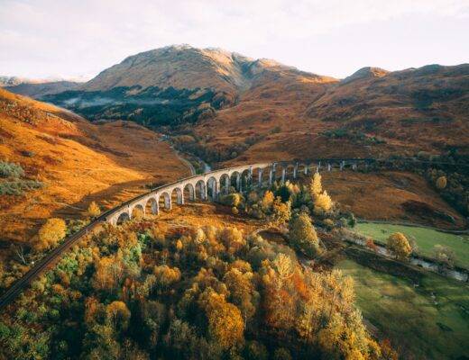 A view of a long railway bridge over a rural autumn landscape