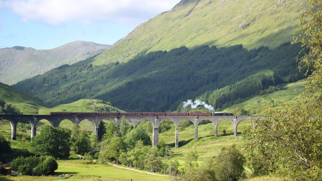 A train travelling on a bridge on the West Highland Line, one of the most scenic train routes in Europe